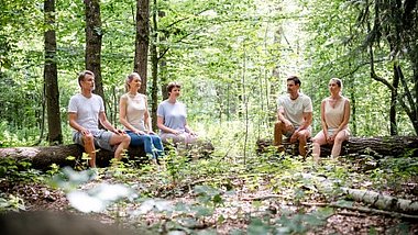 Gruppe sitzt im Wald